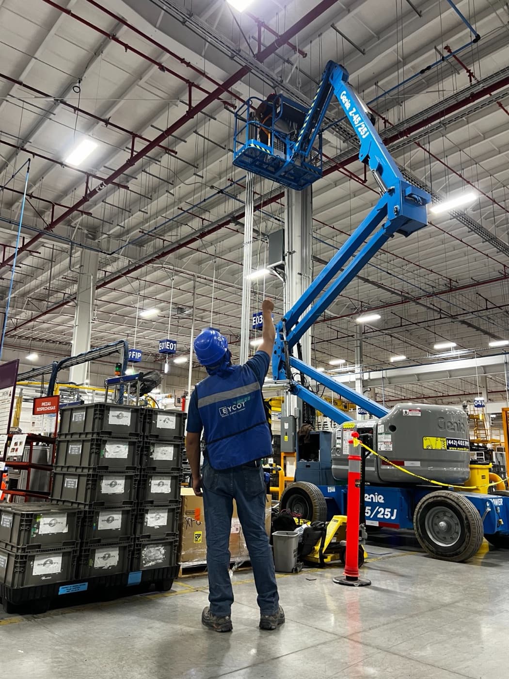 Técnico EYCOT operando plataforma de elevación en planta industrial de alto consumo